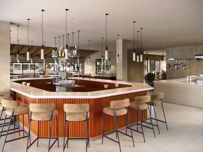 Modern bar med marmorskiva, räfflad terrakottabas och höga pallar i ett ljust socialt utrymme.