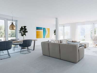 Bright minimalist living room with beige sofa, blue dining chairs, and large windows overlooking a garden.