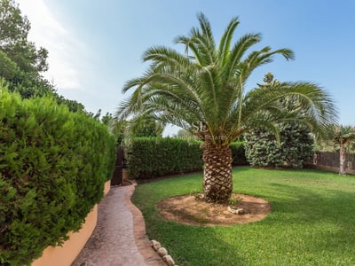 Moderne Ansicht der Villa mit großer Terrasse, Infinity-Pool, Liegestühlen und minimalistischen Gartenmöbeln. Gepflegter Garten.