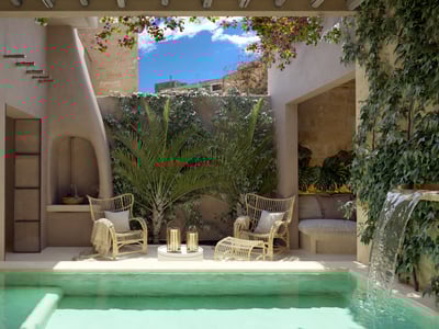 Sunlit courtyard with turquoise plunge pool, waterfall, wicker chairs, and lush greenery under a blue sky.