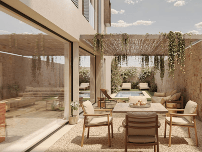 Modern outdoor terrace with a wooden dining table, a stone wall, a pergola with plants, and a pool in the background.