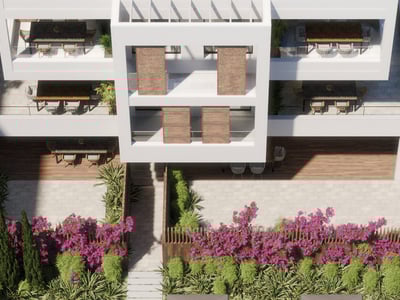 Högvinkelvy av en vit modern byggnad med rymliga terrasser och medelhavsväxter.