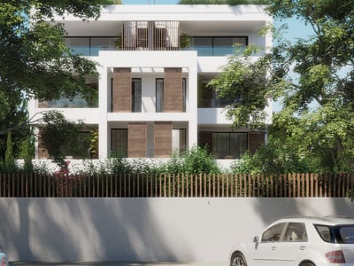 Vit modern fyravåningsbyggnad med träjalusier och glasbalkonger omgiven av stora gröna träd.