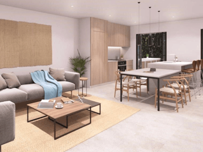 Zeitgemäßes Wohnzimmer mit grauem Sofa, Holzesstisch und integrierter Küche in hellen Tönen.