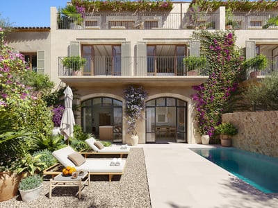 Luxury pool area with sun loungers, stone facade, and vibrant purple bougainvillea climbing the walls.