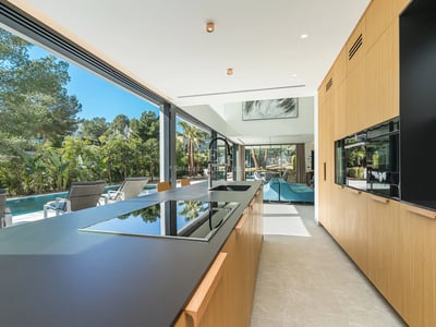 Exteriör av modern villa med infinitypool, stor trädgård och elegant arkitektur. Varm omgivningsbelysning och panoramautsikt.