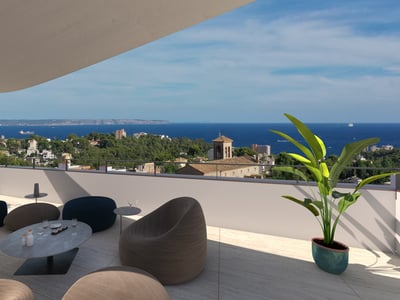 Moderna terraza en la azotea con asientos de diseño y vistas a una ciudad costera mediterránea y al mar azul.