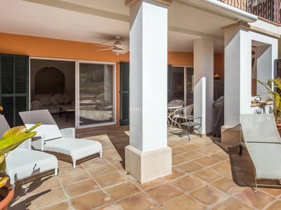 Große Terrakotta-Terrasse mit weißen Sonnenliegen und weißen Säulen im Sonnenlicht.