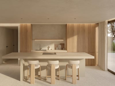 Cocina moderna minimalista con isla beige, armarios de madera clara y tres taburetes de diseño en un espacio luminoso.