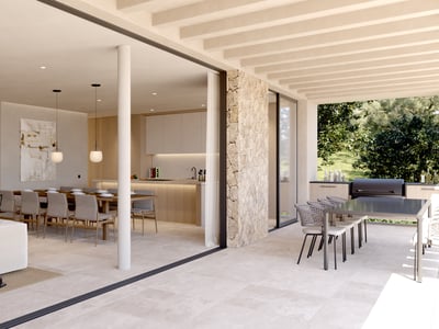 Spacious indoor living room with white sofa flowing into an outdoor terrace with dining and kitchen areas.