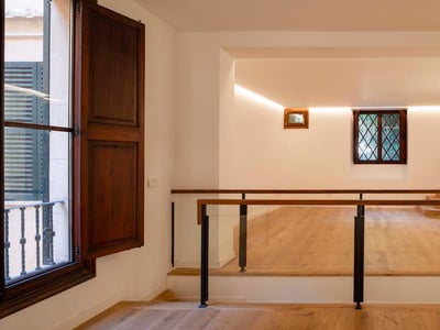 Moderner Flurbereich mit hellem Eichenparkett, Glasgeländern und warmer Voutenbeleuchtung an weißen Wänden.