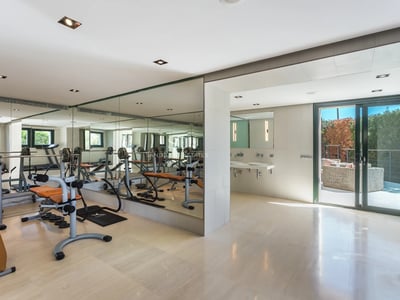 Großes Wohnzimmer mit Panoramafenstern, hellem Holzboden, modernem Kamin und minimalistischem Design. Viel Tageslicht.