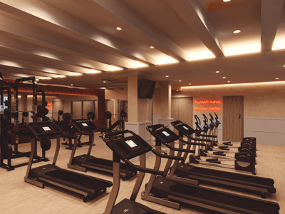 Modernt inomhusgym med löpband, vikter och varm belysning med en neonskylt.