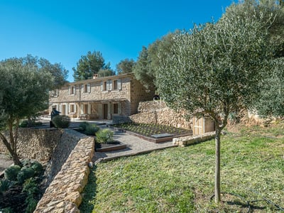 Amplio salón con ventanales, sofás de diseño, chimenea moderna y vistas panorámicas. Lámparas colgantes y suelo de madera clara.