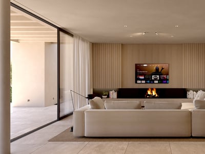 Spacious modern living room featuring a large beige sectional sofa, built-in fireplace, and wood-paneled TV wall.