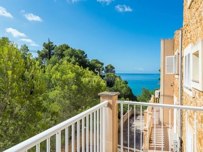 Vista exterior de una villa moderna con piscina, jardín exuberante y amplias ventanas. Arquitectura minimalista, iluminación ambiental.