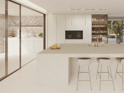 A minimalist modern kitchen featuring a large stone central island, beige bar stools, and natural stone wall accents.