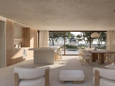 Amplio salón moderno de concepto abierto con cocina, comedor y grandes ventanales con vistas a una piscina y árboles.
