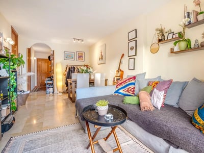 Salón luminoso con grandes ventanales a piscina. Sofá modular beige, alfombra texturizada, y decoración minimalista. Diseño moderno y elegante.