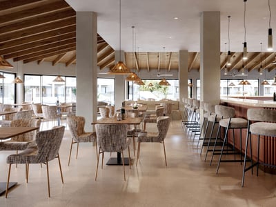 Modern bar with wooden beamed ceiling, wicker pendant lights, and upholstered bar stools.