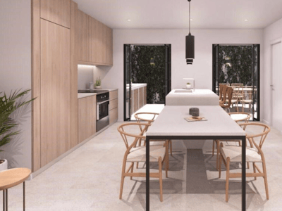 Moderne Küche mit hellen Holzschränken, weißer Kochinsel und integriertem Esstisch mit Holzstühlen.