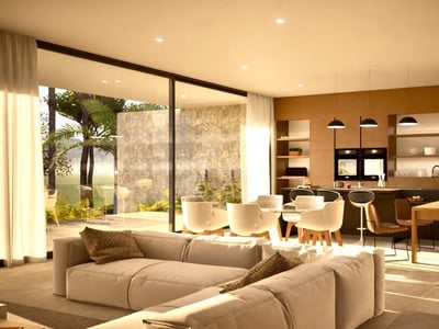 Amplio salón moderno con sofá seccional blanco, comedor y cocina con ventanales que dan a una terraza soleada.