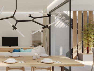 En modern matsal med ett stort träbord och designbelysning, som öppnar upp mot ett ljust vardagsrum.