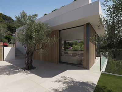 Arquitectura moderna de color blanco con listones de madera, grandes ventanales y un olivo en una terraza de piedra.