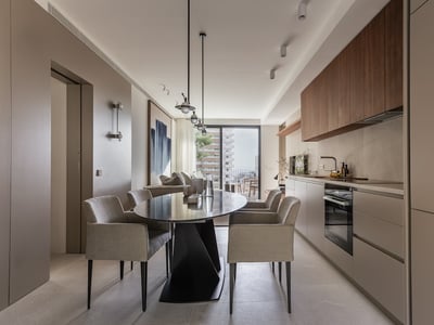 Zeitgenössisches Esszimmer mit ovalem schwarzem Tisch, grauen Stühlen und minimalistischer Küche mit Balkonzugang.