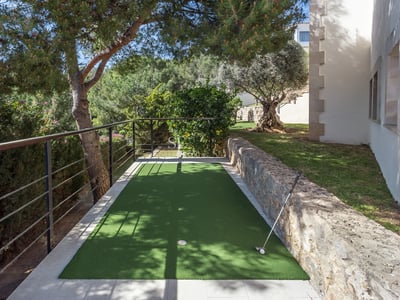 Helles Wohnzimmer mit großen Fenstern, beigem Sofa, modernem Kamin und Panoramablick auf das Meer. Elegantes und minimalistisches Design.