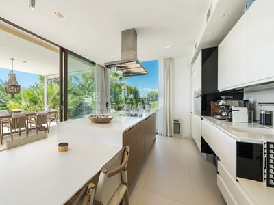 Außenansicht einer Luxusvilla mit Pool, üppigem Garten und moderner Architektur. Ideal für Familien und Unterhaltung.