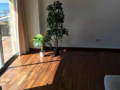 Geräumiges Wohnzimmer mit Fensterfronten, hellem Holzboden, Kamin und modernen Möbeln. Spektakuläre Aussicht.