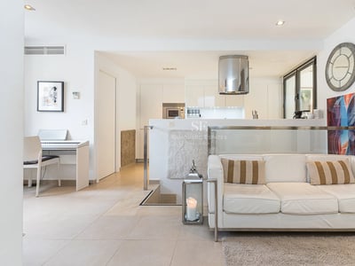 Große Terrasse mit Pool, umgeben von Gärten. Moderne Architektur mit großen Fenstern und luxuriösen Oberflächen.