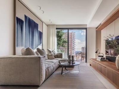 Helles Wohnzimmer mit beigem Sofa, abstrakter Wandkunst, Holz-TV-Konsole und Balkonzugang.