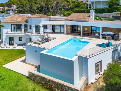 Amplio salón con ventanales, mobiliario moderno y acceso a balcón con vistas impresionantes. Elegancia y luminosidad.