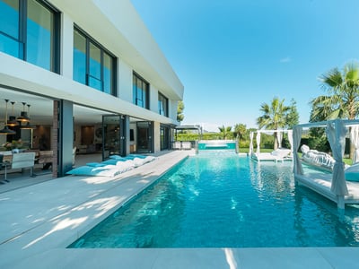 Exterior view of a modern villa with a pool, garden, and spacious terraces. Sleek design and high-quality finishes.