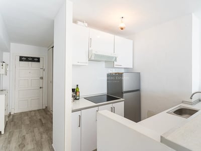 Großer Balkon mit Meerblick. Glasgeländer, Holzboden und moderne Möbel schaffen einen eleganten und entspannenden Raum.