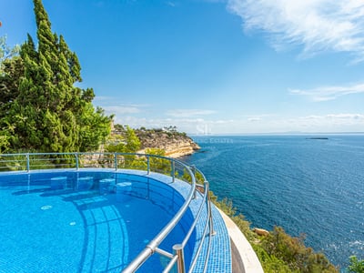 Spacious balcony with sea view, modern furniture, glass railing. Bright and elegant space. Architectural design details.