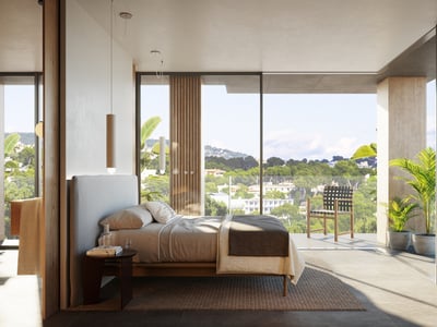 Ljust sovrum med fönster från golv till tak, privat terrass och utsikt över lummig natur.