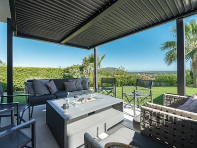 Spacious balcony with panoramic sea views. Modern, minimalist design with glass railing and outdoor furniture.