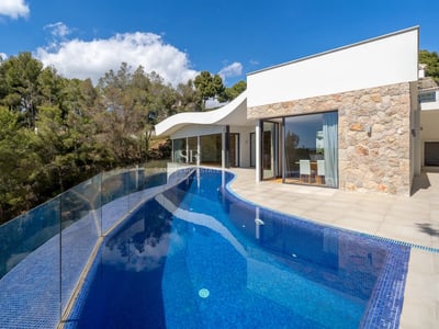 Geräumiges Wohnzimmer mit Fensterfronten, Tageslicht, minimalistischen Möbeln und Zugang zu einer Terrasse mit Meerblick. Modernes und elegantes Design.
