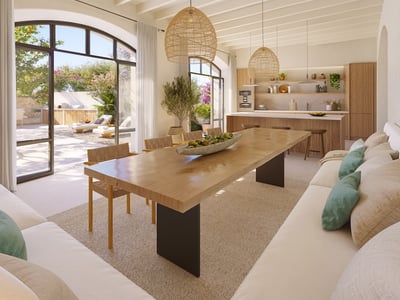 Spacious dining area with a long wooden table, wicker lamps, and large arched windows leading to a sunny terrace.