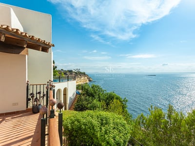Exterior view of a modern house featuring a pool, lush garden, and large windows illuminating the interior.