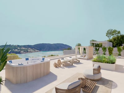 Terraza soleada con jacuzzi de madera, tumbonas y sofás frente a una bahía costera.