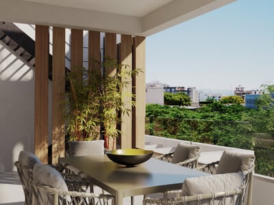 Modern terrass med matbord, flätade stolar, trälister och glasräcke med utsikt över staden.