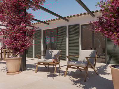 Stenterrass med två träfåtöljer, gröna fönsterluckor och rosa bougainvillea under en klarblå himmel.