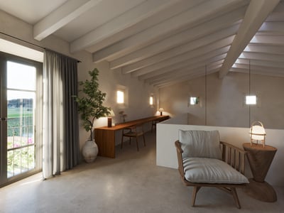 A mezzanine workspace featuring a long wooden desk, exposed white ceiling beams, and a stylish lounge chair by a balcony.