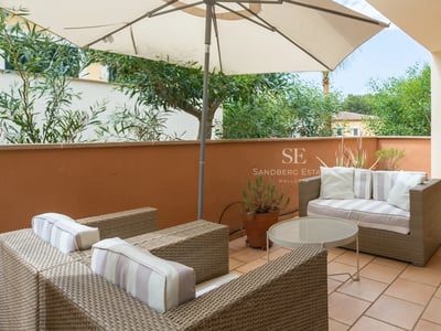 Ansicht einer modernen Villa mit Infinity-Pool, Designermöbeln und üppiger Vegetation. Große Fenster und elegante Architektur.