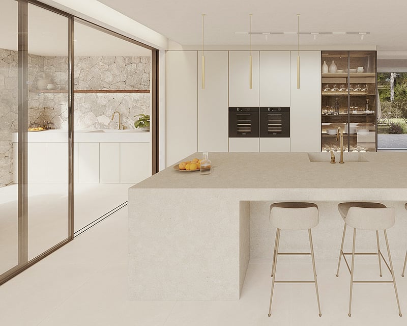 A minimalist modern kitchen featuring a large stone central island, beige bar stools, and natural stone wall accents.