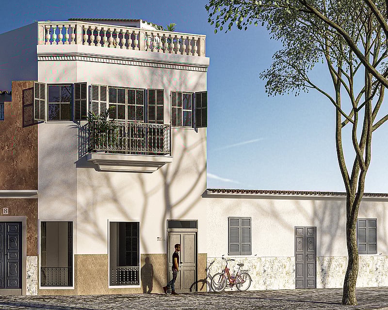 Three-story white and ochre building with traditional shutters, wrought iron balconies, and a stone balustrade on the roof.